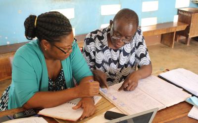 Project staff in Mtwara region, Tanzania, review monitoring data of insecticide-treated nets (ITNs).