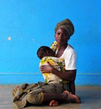 Woman breastfeeds her child while waiting for health services outside a health center in Nampula, Mozambique.