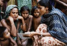 A Family Welfare Assistant shares family planning information with villagers in the Trishad District of Bangladesh.